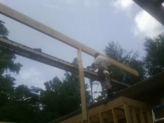 Carpenter setting a ridge beam over a new addition frame — Ice Dam Removal by Roofing Brothers in Eltopia