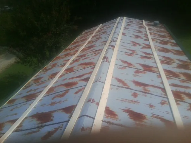 Rusted metal roof panels with new wood purlins before replacement — Storm Damage Roof Repair in Eltopia by Roofing Brothers