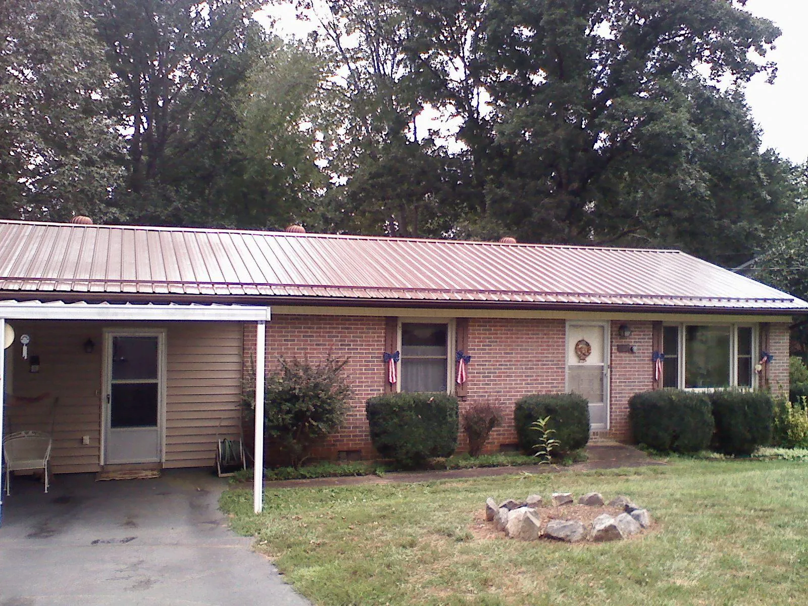 Bronze metal roof and carport on a brick ranch home — Roof Repair work by our crew in Eltopia